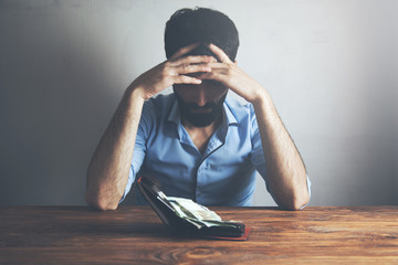 Sad man with wallet and money