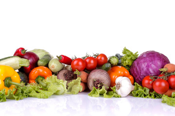 a variety of fresh vegetables including tomato pepper cabbage beetroot zucchini and carrot leaves garlic and cucumber salad on white isolated background