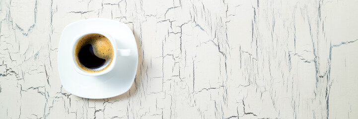 Coffee cup on old kitchen table. Coffee for breakfast. Top view with copy space. Long web format for banner
