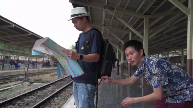 The concept of being careful during travel : Thief was stolen mobile phone of Asian tourists while he was look his map.