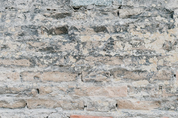 Beige and black grungy ancient brick stone wall in Spain
