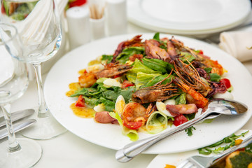 Healthy Shrimp and Salad with orange and Tomatoes, wine on a white background