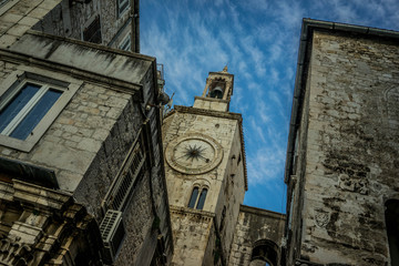 Ancient stone clock tower against a dramatic blue sky in an old town, Split, Croatia