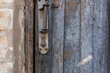 old wooden door with peeling and cracked grey paint