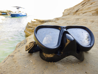 Diving mask for scuba diving on the rock near the sea