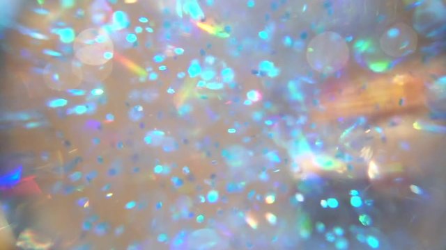Close up inside a snow globe with blue and teal flakes floating around, in slow motion