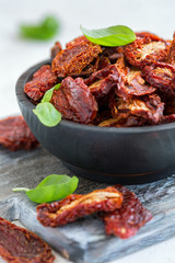 Sun-dried tomatoes in an old wooden bowl.