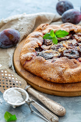 Homemade plum pie with a sprig of mint.