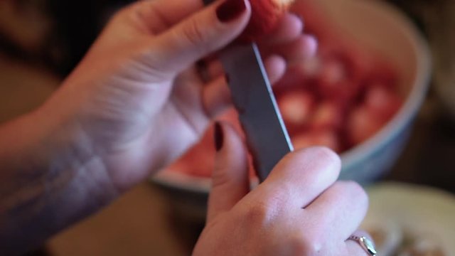 Woman cutting strawberries in her hand, in slow motion