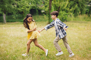 Fototapeta premium Two happy children having fun outside in summer. Adorable little children running around in forest having fun time together.