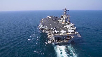 An aerial over an aircraft carrier at sea.