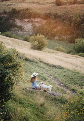 in autumn a girl in a hat is walking with a white dog © Andrii