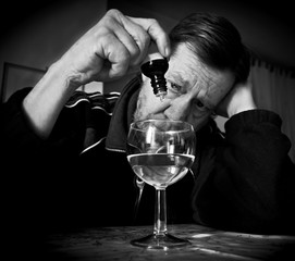 Uomo anziano in procinto di dosarsi un medicinale.