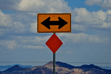 Stop. Which Way, left or right? Traffic sign with two arrows that direct drivers to turn right or left