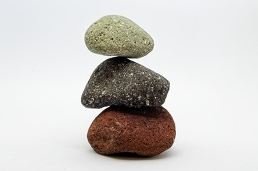 Fototapeta na wymiar Pyramid of three colored stones over white background