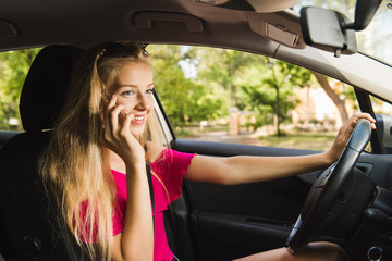 Fototapeta na wymiar Girl driver talk by mobile phone in car