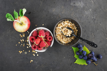 Ingredients for healthy breakfast meals: raspberries, blueberries, nuts, orange, bananas, grapes blue, green, apples, kiwi. Top View.