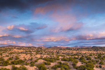 Naklejka premium Dramatyczne kolorowe chmury o zachodzie słońca nad górami Sangre de Cristo i pustynią w pobliżu Santa Fe w Nowym Meksyku
