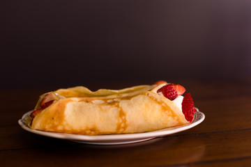 Golden crepes stuffed with strawberries and whipped cream.