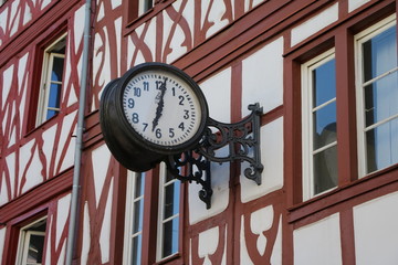 Fototapeta na wymiar Clock at half-timbered house in old town of Trier, Germany