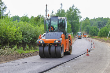 Work on laying of an asphalt paving by means of heavy machinery