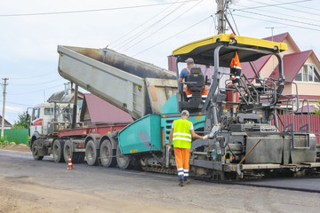 Work on laying of an asphalt paving by means of heavy machinery