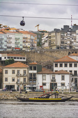 Fototapeta na wymiar Boat in the Douro river with wine cellars, Porto, Portugal