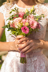 Obraz na płótnie Canvas A bride holding wedding bouquet in her hands