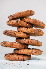 Chocolate chip cookies on white background. Stacked chocolate chip cookies on brown napkin. Symbolic image with place for text. Freshly baked. Concept for a tasty snack. Sweet dessert
