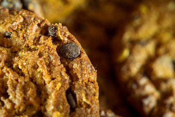 Chocolate chip cookies on rustic dark black background. Stacked chocolate chip cookies on brown napkin. Symbolic image with place for text. Freshly baked. Concept for a tasty snack. Sweet dessert