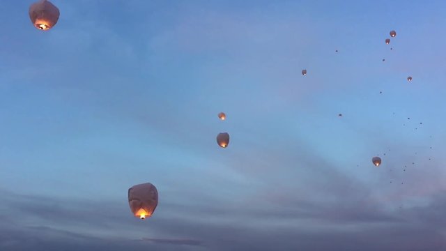 Group of sky lanterns floating away at dusk