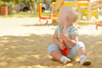 A little girl playing in the sandbox