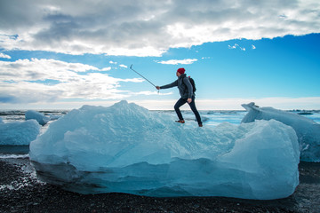Tourist man taking selfie on small iceberg Located in Diamond beach near Jokulsarlon Lagoon, Iceland