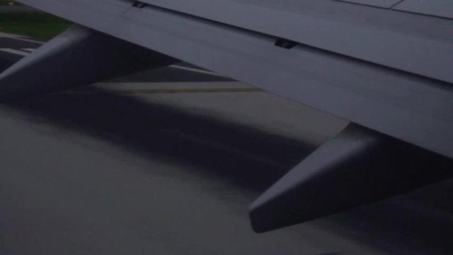 Airplane wing during a morning takeoff, in slow motion