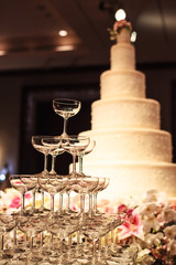 wedding cake with champagne glass tower on the table at the stage in wedding ceremony. Wedding Ceremony tools and decorations concept.