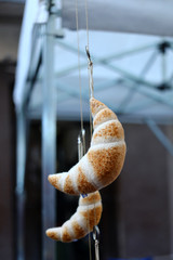 BUENOS AIRES, ARGENTINA - AUGUST 24, 2018: Typical argentinian sweet bread called Medialuna  made into a toy hanging in the street in Buenos Aires, Argentina