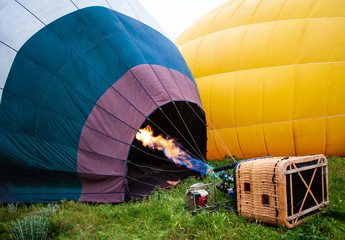 Hot air balloon getting ready to launch. Large gas burner flame filling balloon with hot air