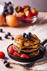 Stack of homemade pancakes with blueberries and strawberries, perfect for breakfast
