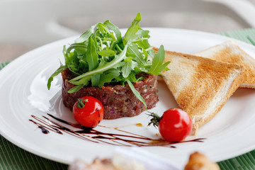 Beef tartare with arugula and cherry tomatoes.