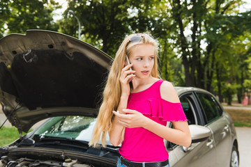 Sad girl in stress with mobile phone near car