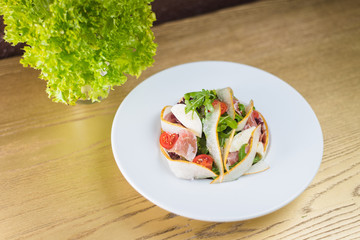 salad with jamon and pear on a white plate