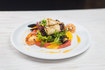 salad of seafood and citrus, on a white plate