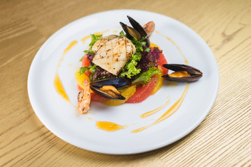 salad of seafood and citrus, on a white plate