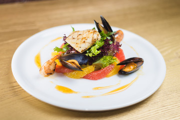 salad of seafood and citrus, on a white plate