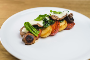 vegetables and mushrooms grilled with basil, on a white plate
