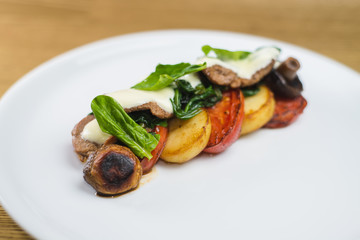 vegetables and mushrooms grilled with basil, on a white plate