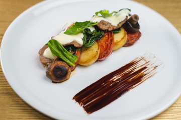 vegetables and mushrooms grilled with basil, on a white plate