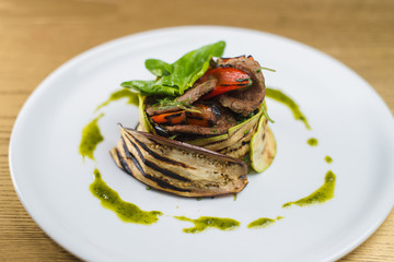 meat with grilled vegetables, on a white plate