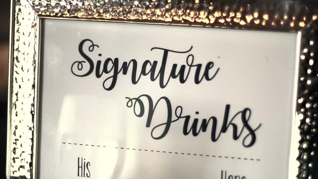 Framed sign with "Signature Drinks" at a bar