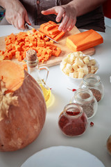 Woman hands chopping carrot on wooden board